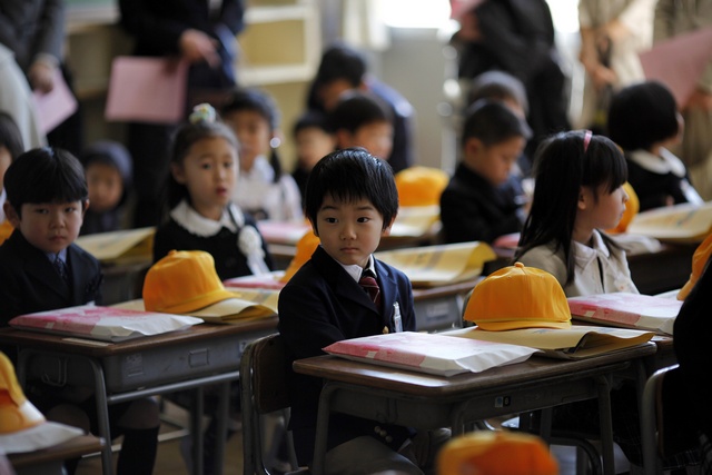 Children sit inside a classroom on their first day of school at Shimizu elementary school in Fukushima, northern Japan April 6, 2011. Over 70 schools began their regular classes on Wednesday in the city of Fukushima, after the earthquake and tsunami that hit the country on March 11. REUTERS/Carlos Barria (JAPAN - Tags: DISASTER EDUCATION SOCIETY)