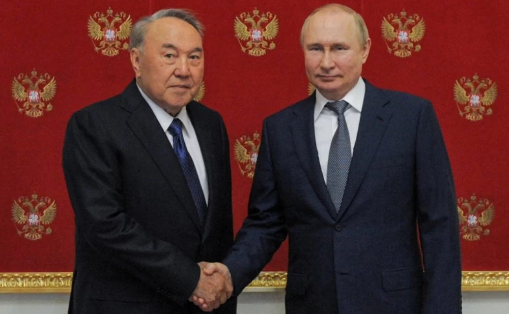 Нұрсұлтан Назарбаев пен Владимир Путин қол алысып тұр