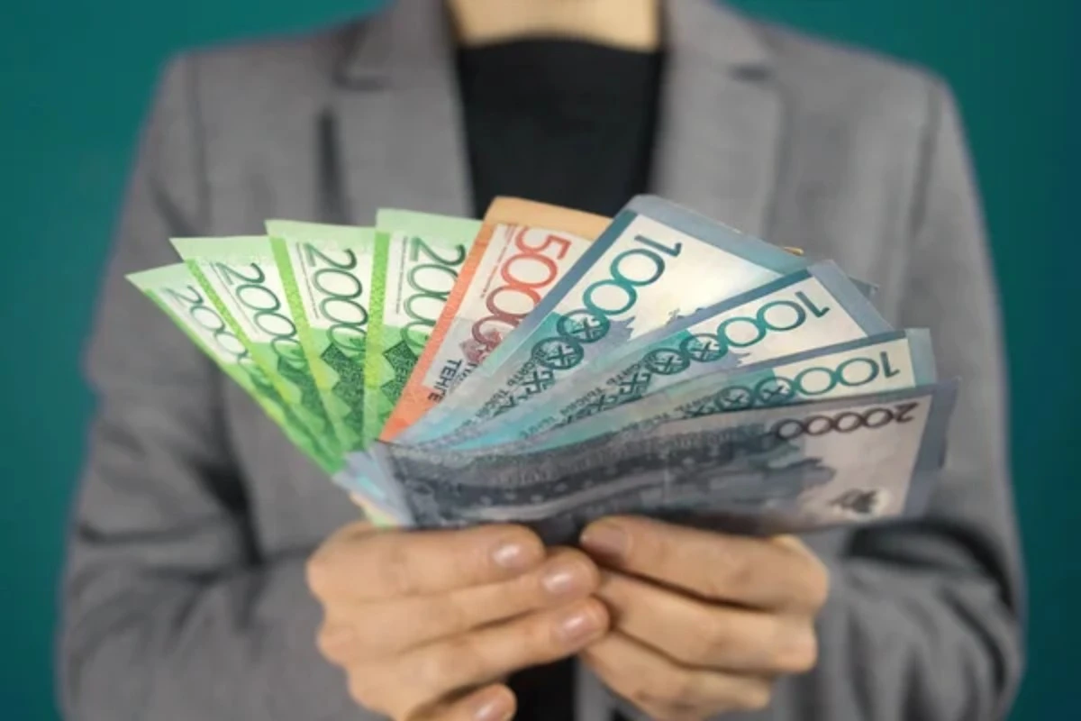 Қолына теңге ұстаған әйел