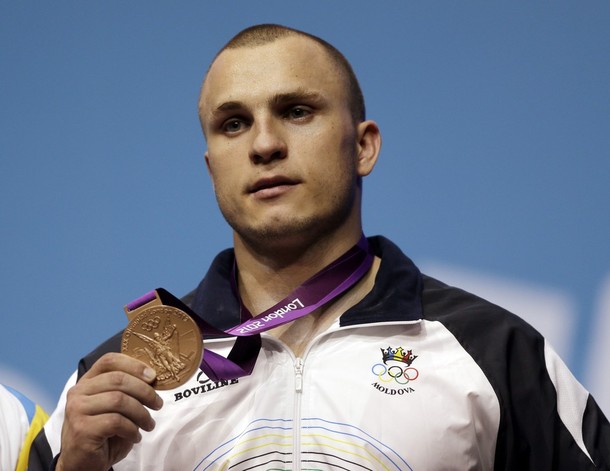Bronze medalist Moldova s Anatoli Ciricu shows his medal during the awards presentation after the men's 94-kg weightlifting competition at the 2012 Summer Olympics, Saturday, Aug. 4, 2012, in London.(AP Photo/Mike Groll)