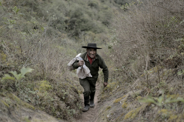 In this July 28, 2016 photo, Pedro Luca walks down the mountain to San Pedro de Colalao, in Argentina's northern province of Tucuman. Luca has lived in a cave in northern Argentina for 40 years. When he gets hungry he picks up his rifle and goes hunting or he goes on a three-hour trek down the mountain to the nearest settlement of San Pedro de Colalao. (AP Photo/Alvaro Medina)