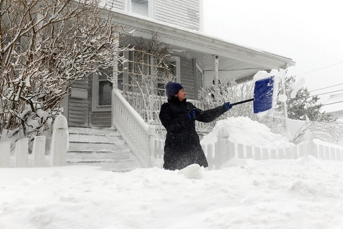 WINTHROP, MA - FEBRUARY 09: A woman shovels snow on Shirley Street February 9, 2013 in Winthrop, Massachusetts. An overnight blizzard dropped two to three feet of snow, with coastal flooding expected as the storm lingers into the day. (Photo by Darren McCollester/Getty Images) ORG XMIT: 161174540