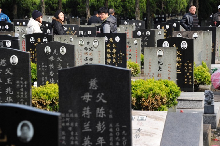 People walk through tombstones during Qingming Festival, or Tomb Sweeping Day, at a cemetery in Shanghai, China, 4 April 2013. China has been celebrating Qingming Festival, or Tomb Sweeping Day, which falls on April 4 this year, with millions of people across the country visiting the graves of their ancestors and commemorating the dead. Tomb Sweeping Day, which began around 2,500 years ago, consists of placing a white rooster on the grave. The ceremony was attributed to the Tang emperor Xuanzong in 732BC, who said too many wealthy people were holding extravogent ceremonies for their ancestors. He said respects could only formally be paid at their deceased family members graves on Qingming, the first day of the fifth solar term. Last year, 520 million people visited their ancestors tombs during the festival.