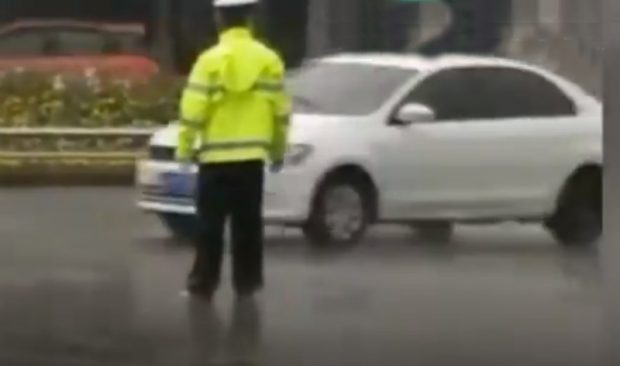 Жол полициясы қызметкері жаңбыр кезінде жұмысына жалаңаяқ шыққан (видео)